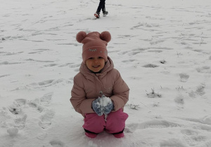 Dziecko robi kulkę ze śniegu